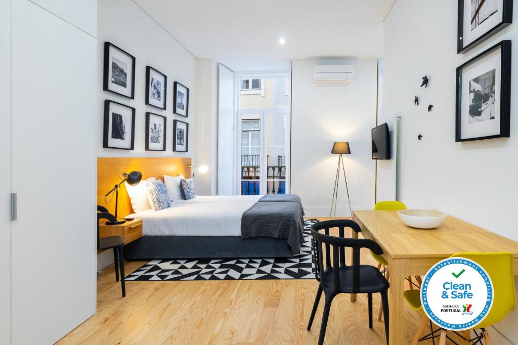 um quarto com uma cama, uma secretária e uma mesa em Porta do Mar Deluxe Central Apartments em Lisboa