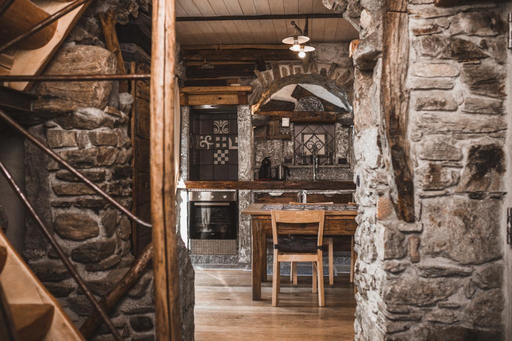 a kitchen with a table and a stone wall at Appartamenti montemezzo le case in pietra Vista lago in Gera Lario