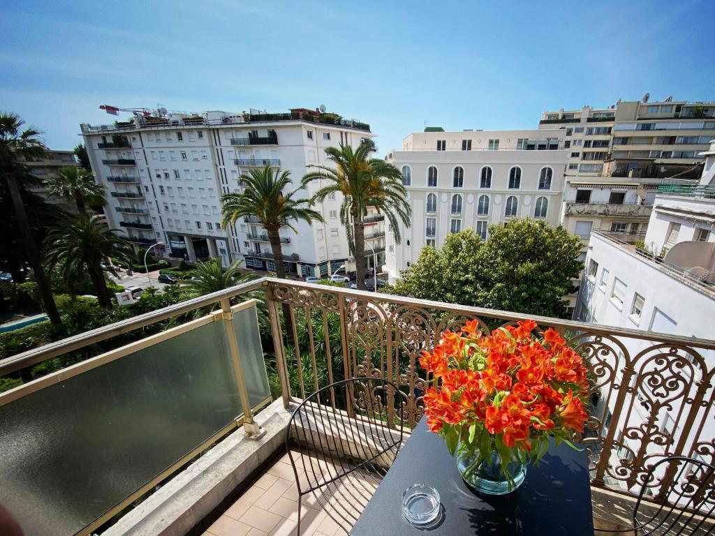 a vase of flowers sitting on a table on a balcony at Hotel Molière in Cannes