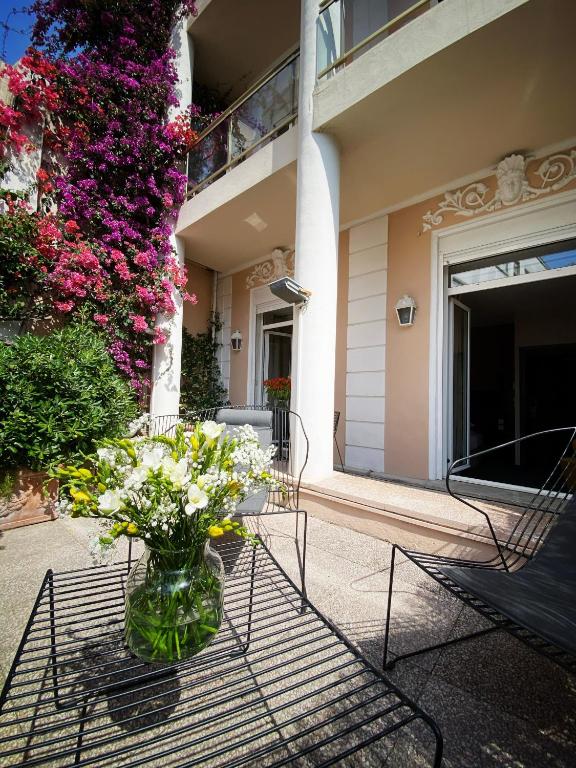 a vase of flowers on a table in front of a building at Hotel Molière in Cannes