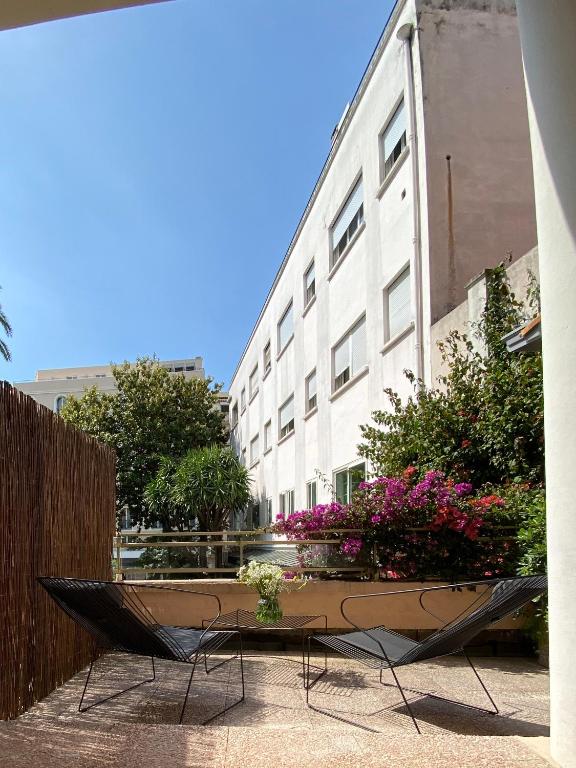 a table and chairs in front of a building at Hotel Molière in Cannes