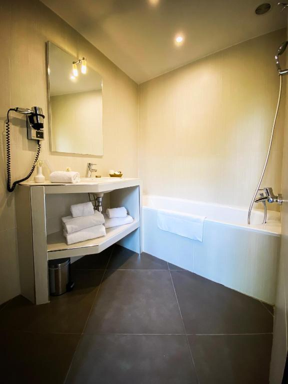 a bathroom with a sink and a bath tub at Hotel Molière in Cannes