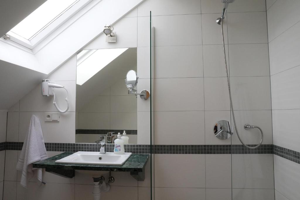 a bathroom with a sink and a shower at Motelik Grosar Jasło in Jasło
