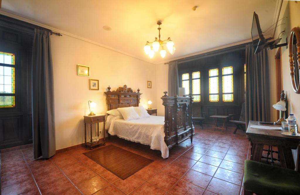 1 dormitorio con cama, mesa y ventanas en Hotel Mar de Queo, en Carballo