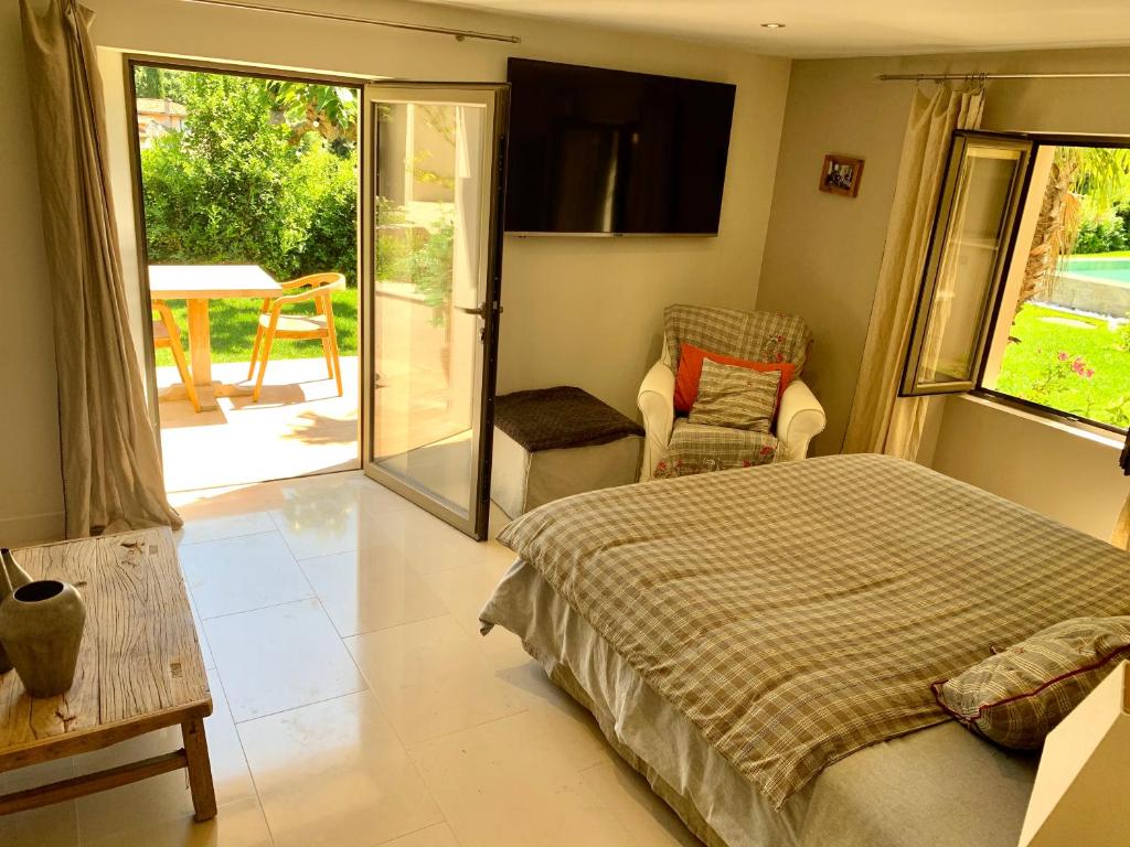 a bedroom with a bed and a chair and a patio at villa Sant-Anna in Saint-Tropez