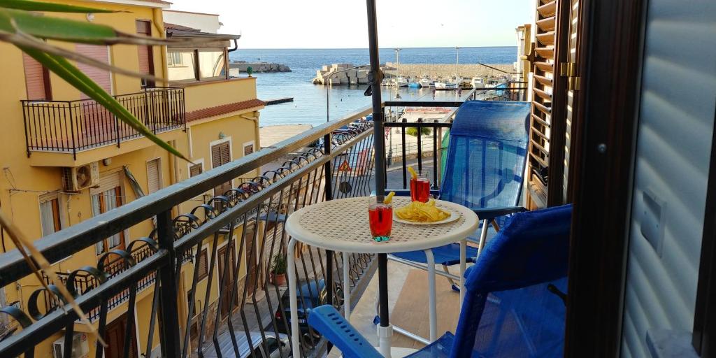 d'une table et de chaises sur un balcon avec vue sur l'océan. dans l'établissement La Rosa dei Venti, à Isola delle Femmine
