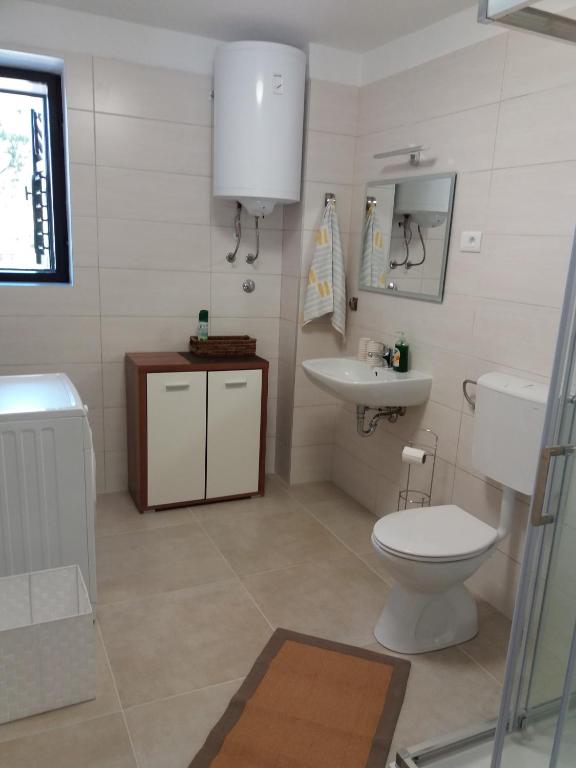 łazienka z toaletą i umywalką w obiekcie House Mergi 2 w mieście Pomer