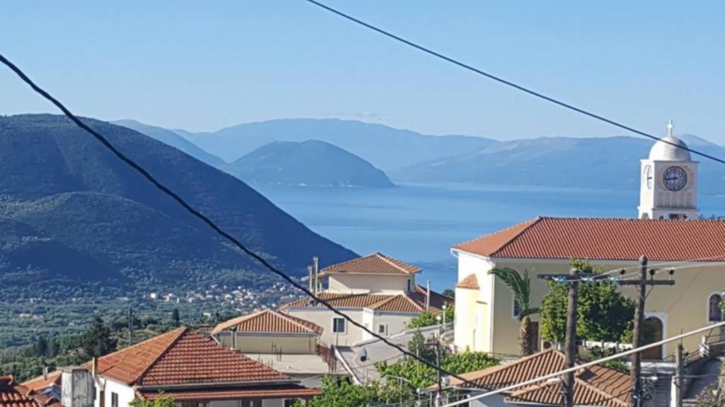 a view of a town with a clock tower at Philoxenia Home in Áyios Pétros