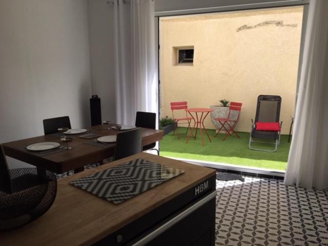 a dining room with a table and chairs and a large window at Maison de charme Isle sur la Sorgue in LʼIsle-sur-la-Sorgue