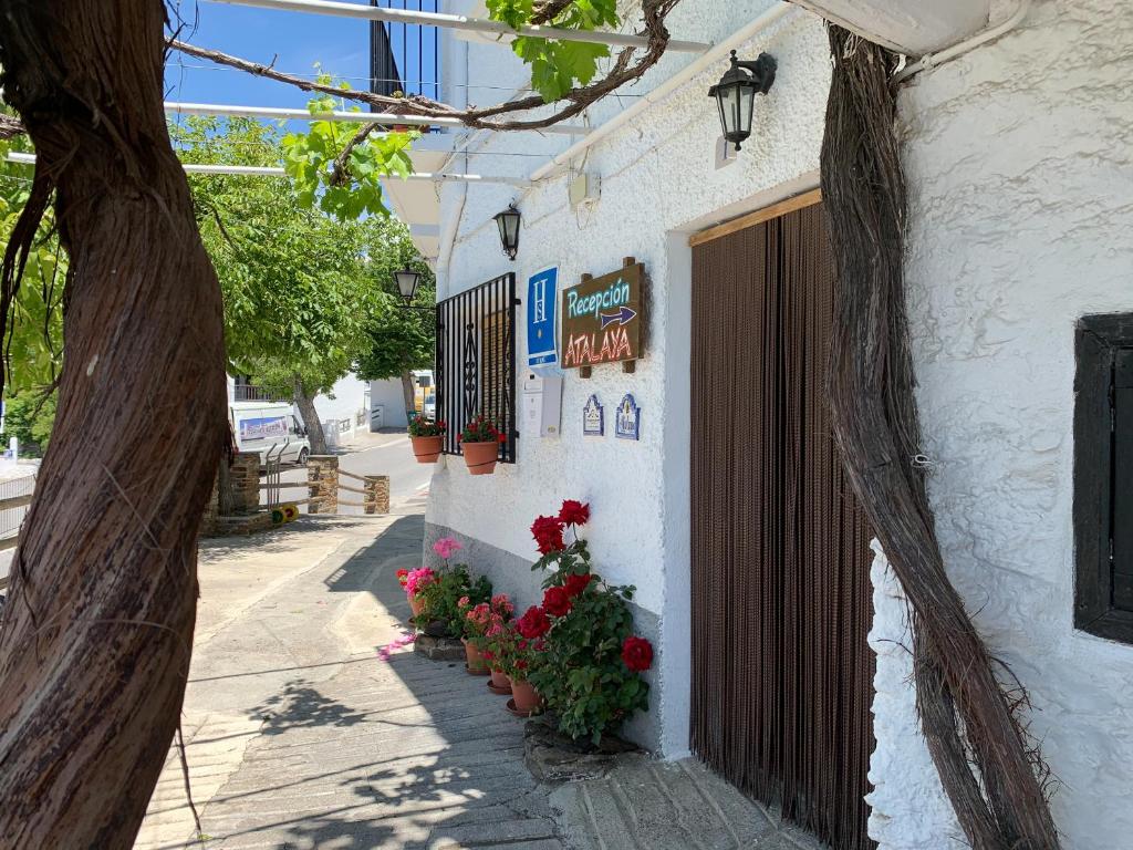 un edificio con flores a un lado. en Hostal Atalaya en Capileira CB, en Capileira