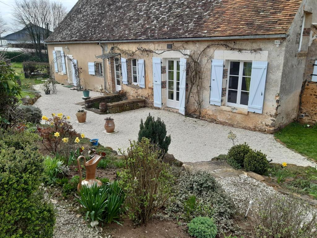 una casa antigua con un jardín delante de ella en La Treille en Treigny