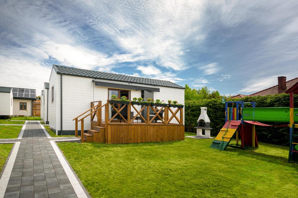 un cortile con una casa e un parco giochi di Domki z klimatem a Ustka