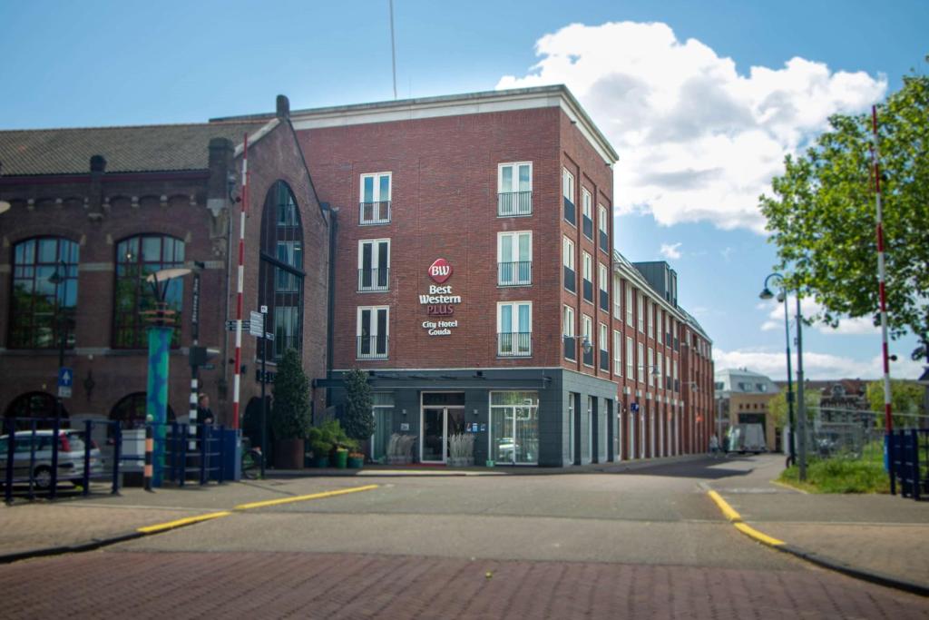 um grande edifício de tijolos vermelhos numa rua da cidade em Best Western Plus City Hotel Gouda em Gouda