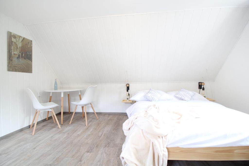 a bedroom with a bed and a table and chairs at Pension Adel in Český Krumlov