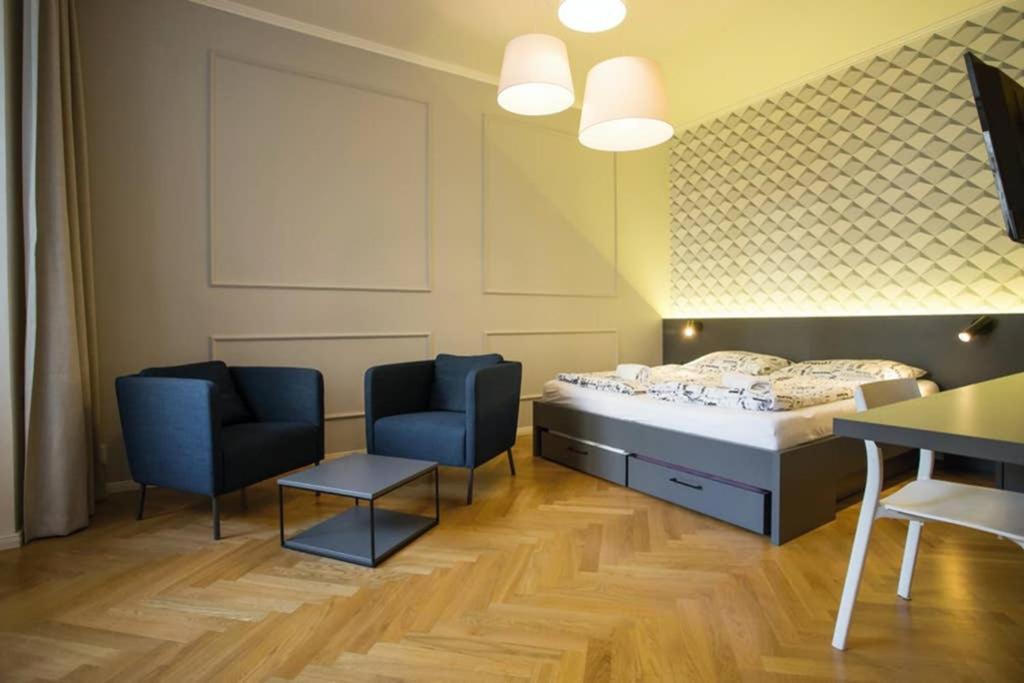een kamer met een bed en twee stoelen en een tafel bij Design Studio Anděl, All Historical Sights Walkable in Praag
