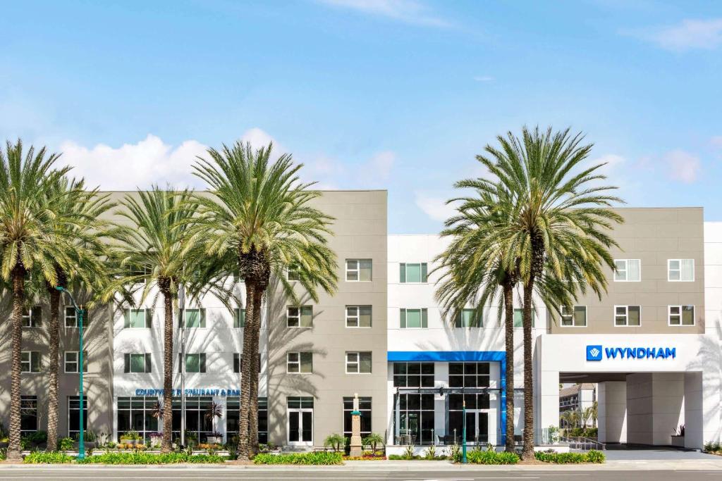 a group of palm trees in front of a building at Wyndham Anaheim in Anaheim