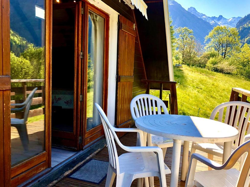 a table and chairs on the porch of a cabin at chalet de venosc in Vénosc