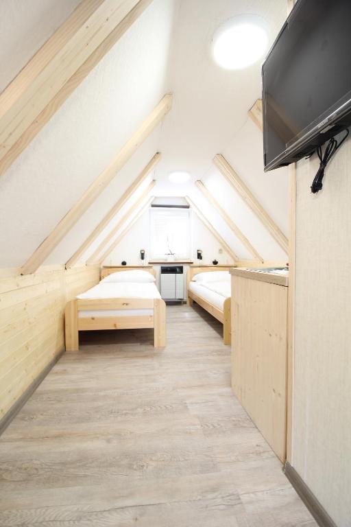 a room with two beds and a flat screen tv at Pension Adel in Český Krumlov