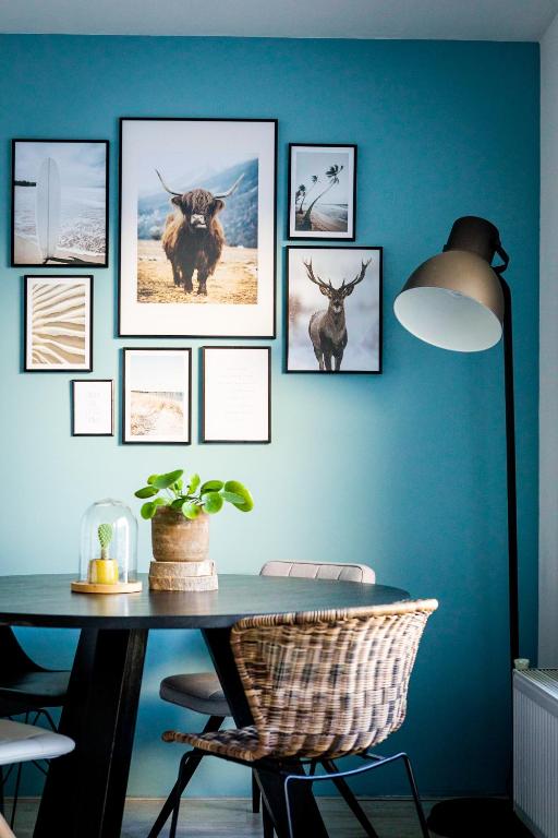 a table with pictures of animals on a blue wall at Studio Puuur in Zandvoort