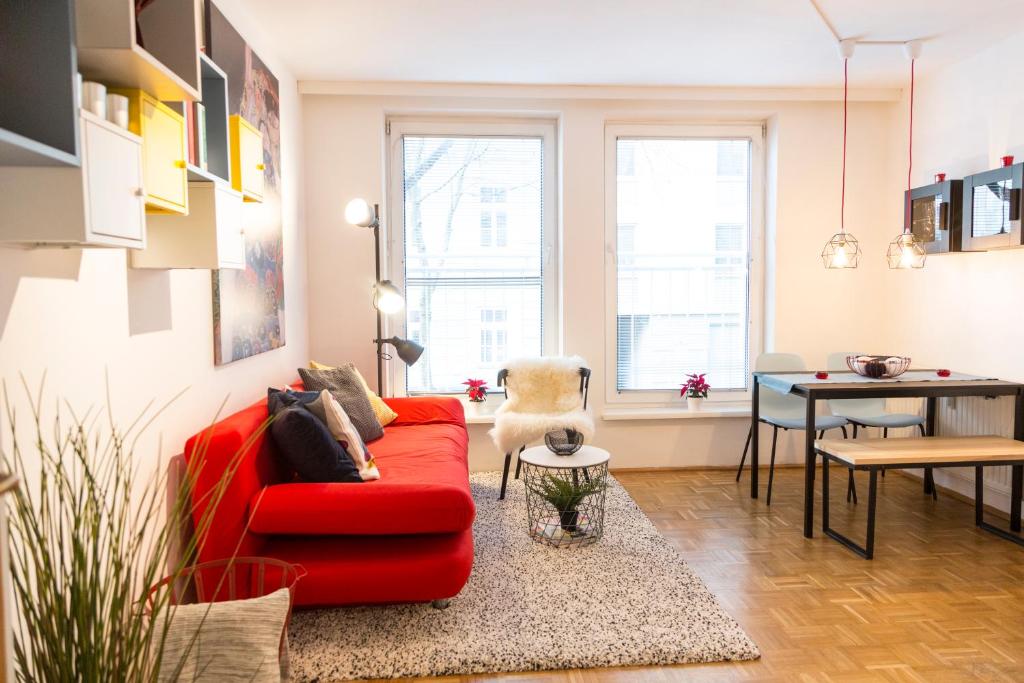 un soggiorno con divano rosso e tavolo di Your Cozy Home * 12 min to City Center a Vienna