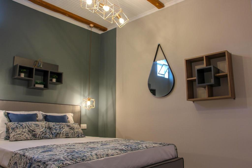 a bedroom with a bed and a mirror on the wall at Lamprini's Deluxe Studios in Limenas