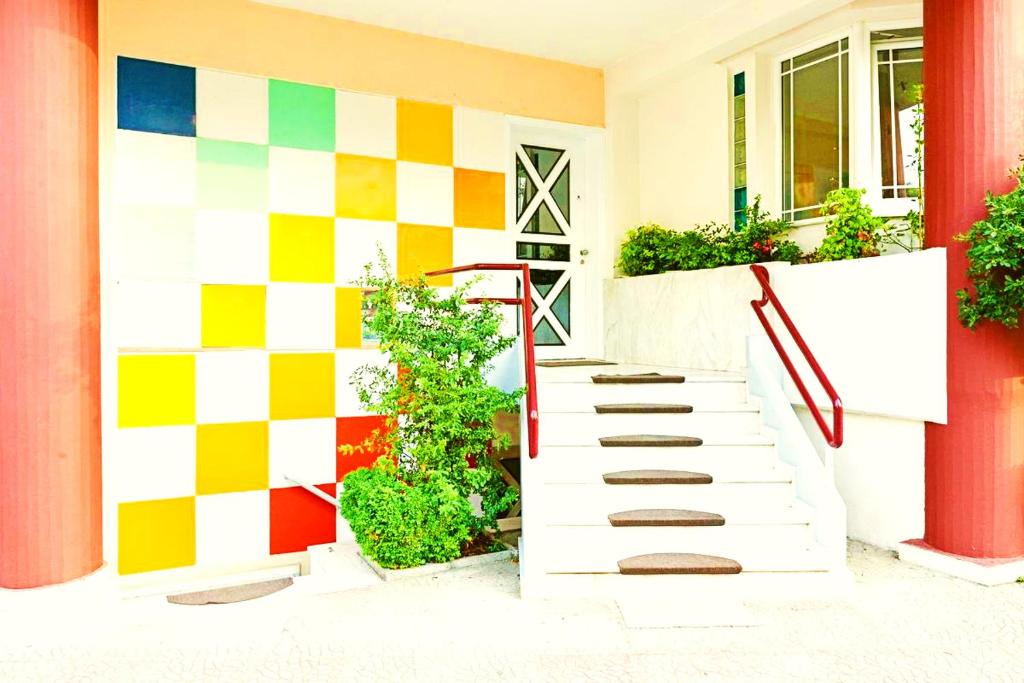 dom z kolorową ścianą i schodami w obiekcie Nomads Meteora w mieście Tríkala