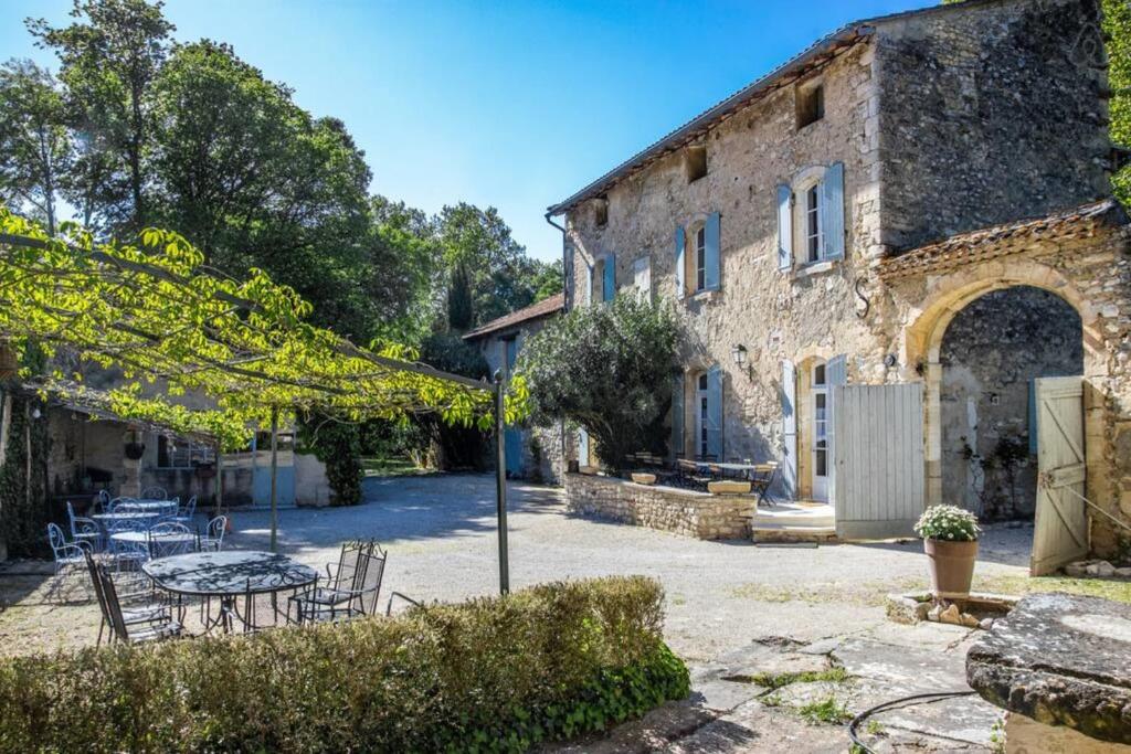 une maison en pierre avec une table et des chaises dans une cour dans l'établissement Stunning farmhouse with heated private pool in Provence, à Pernes-les-Fontaines