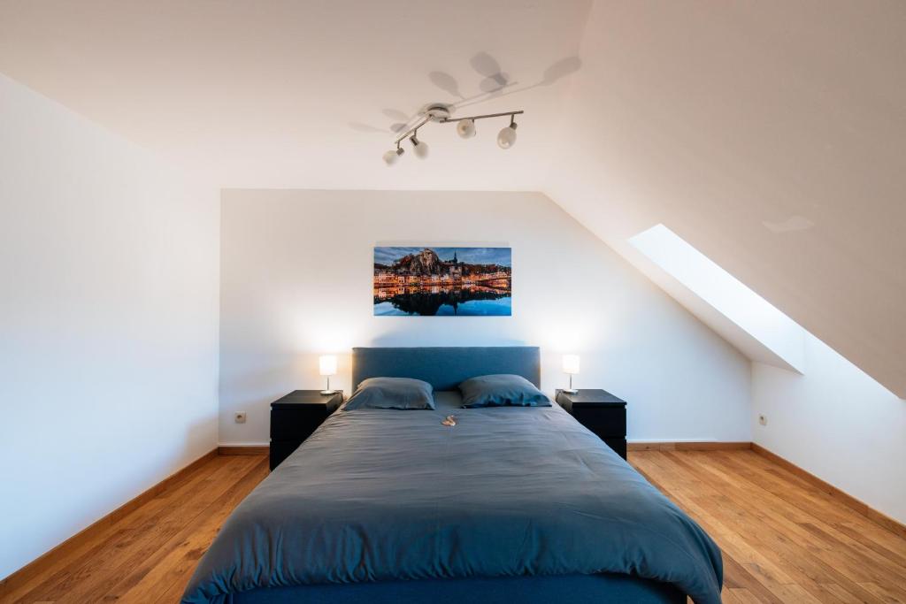 een slaapkamer met een blauw bed en 2 nachtkastjes bij Les rives de Sax in Dinant