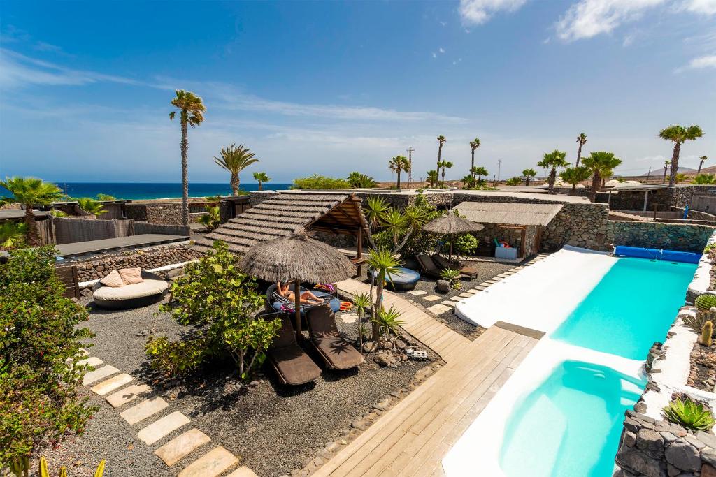 a resort with a swimming pool and the ocean at Eco Village Finca De Arrieta in Tabayesco