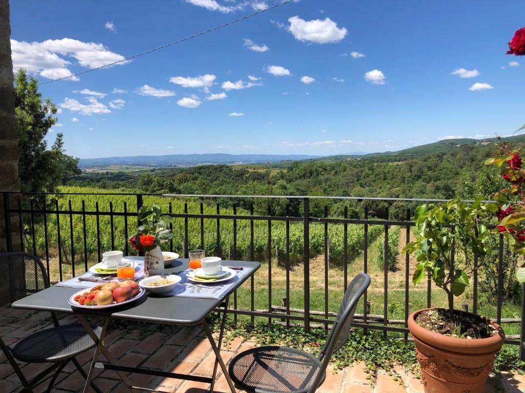 a table with a plate of fruit on it on a balcony at Agriturismo Oliviera Winery & Hiking in Vagliagli