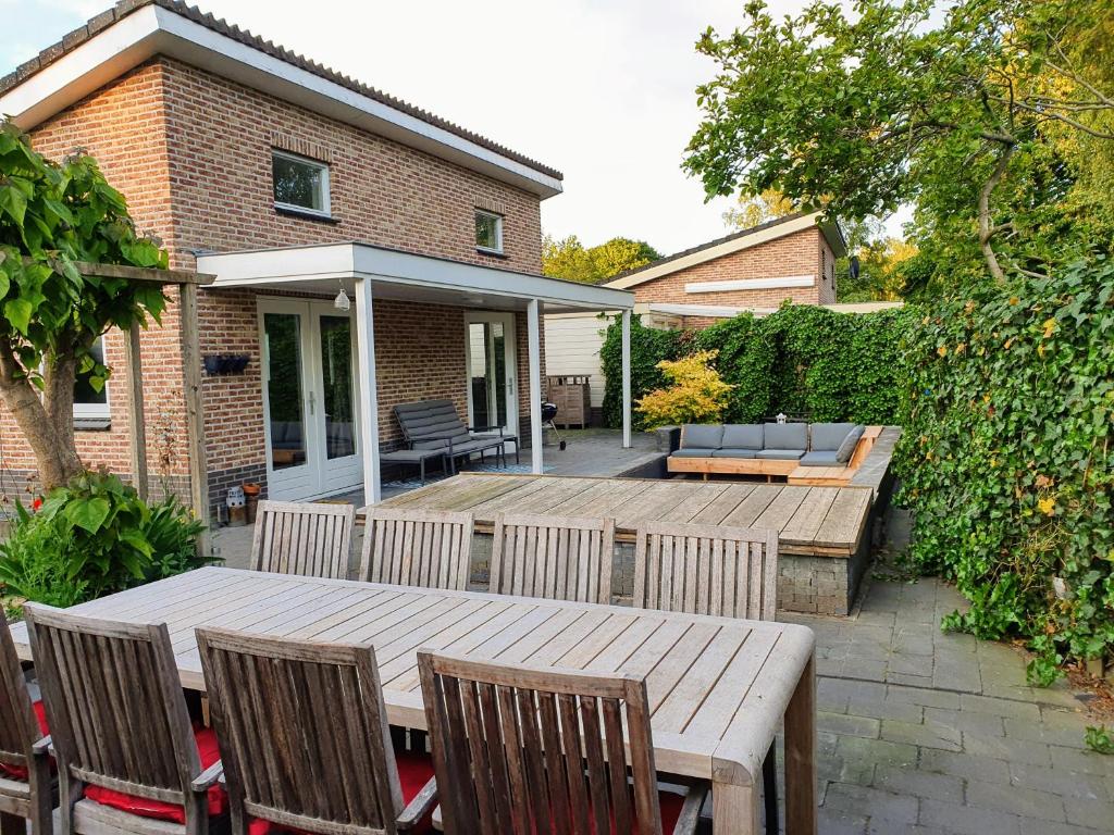 a patio with a wooden table and chairs at De stille Kern in Putten