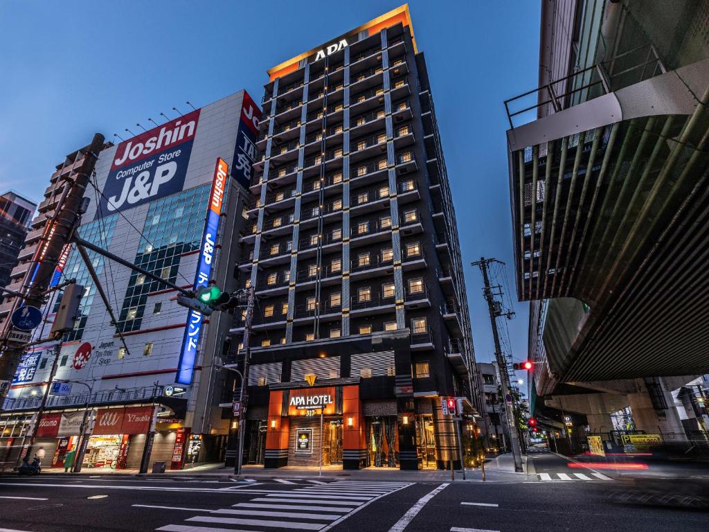 a tall building on a city street at night at APA Hotel Nambaminami Ebisucho Eki Shinsekai in Osaka