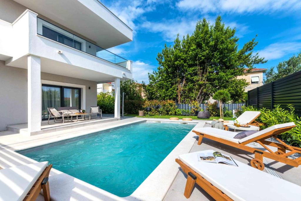 una piscina nel cortile di una casa di Villa Auni Grey - Heated Pool - Rooftop - Seaview - Beach a Kaštela (Castelli)