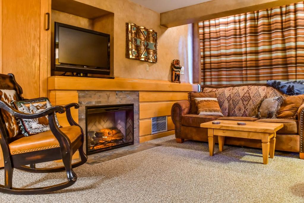 a living room with a fireplace and a tv at Shoshone in Big Sky