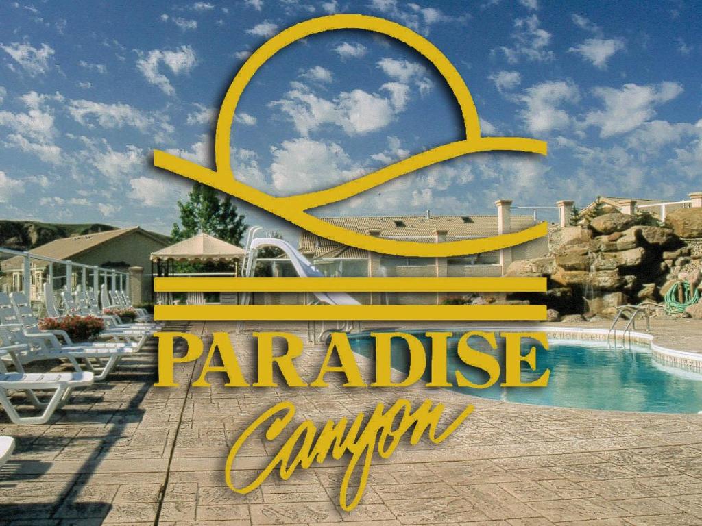 um sinal que diz cambio paraíso ao lado de uma piscina em Paradise Canyon Golf Resort - Luxury Condo M403 em Lethbridge