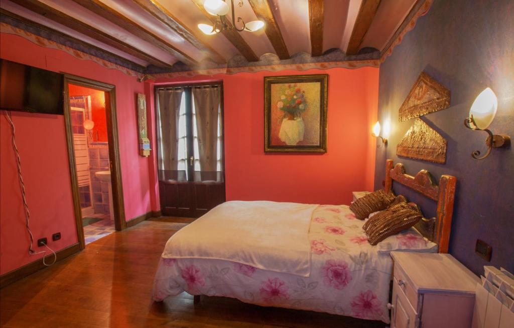 una camera da letto con pareti rosse e un letto in esso di Lupardika a Orduña