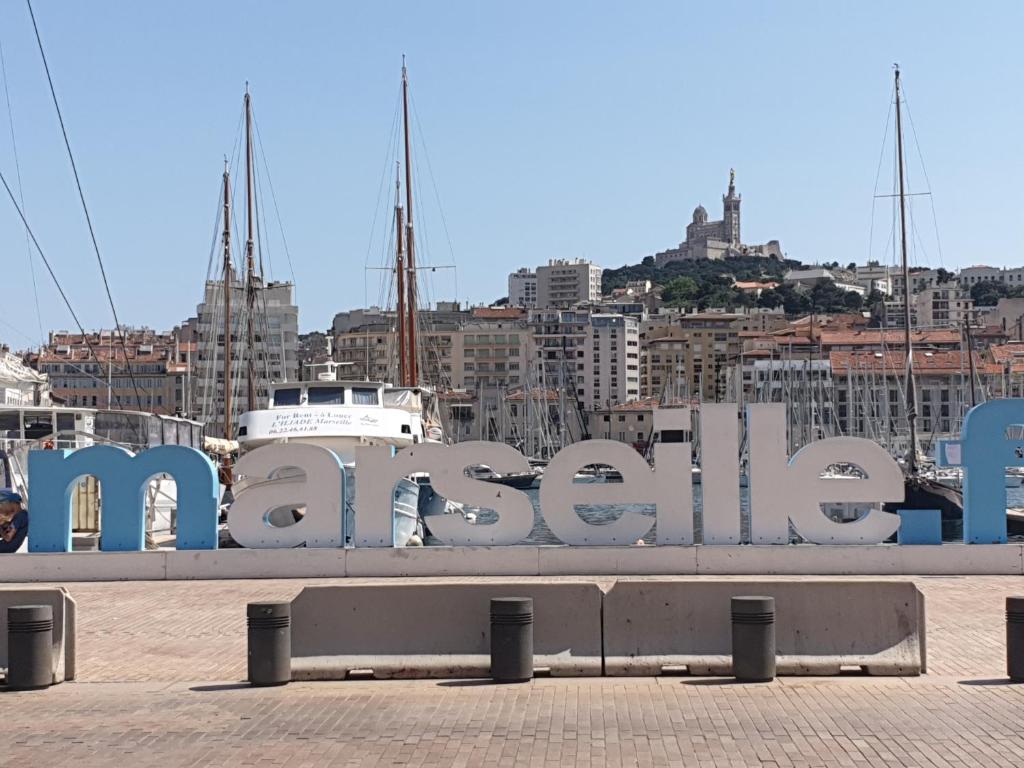 a sign for the marina with a city in the background at Appartement Panier Vieux port in Marseille