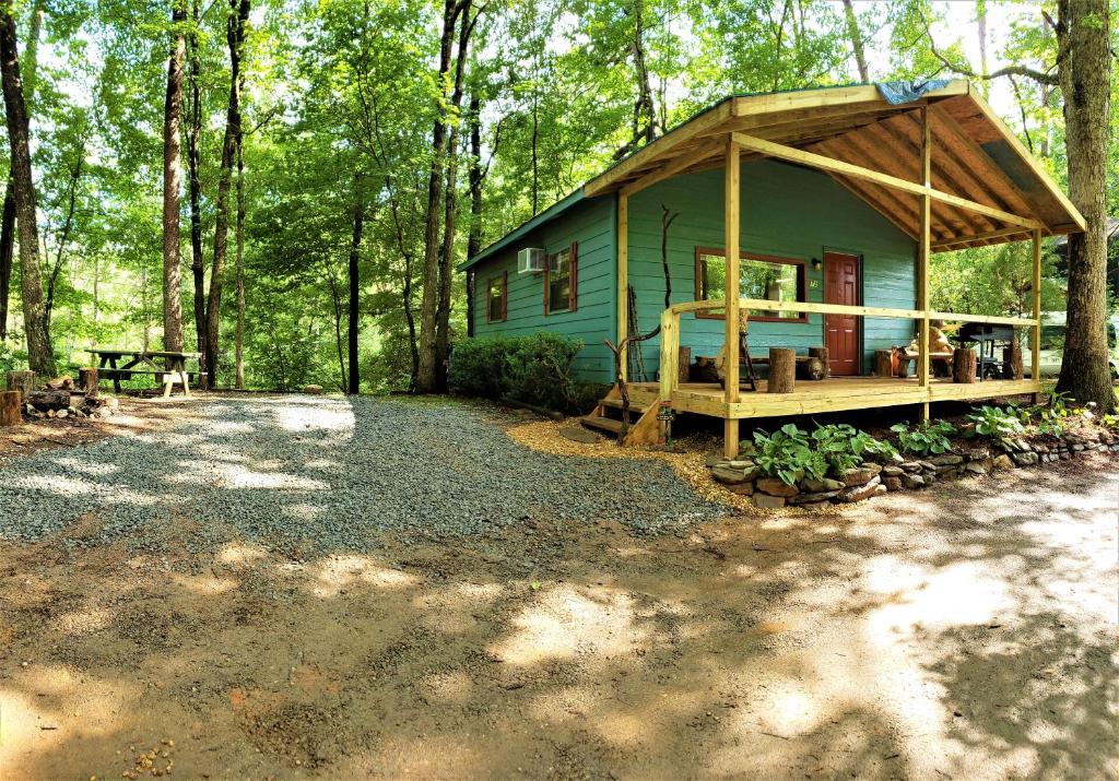 a green house in the middle of a forest at Mountain Laurel Cottage at Hearthstone Cabins and Camping - Pet Friendly in Helen