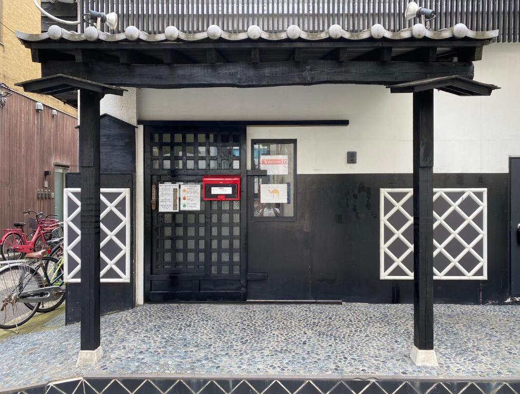 czarne drzwi budynku z bramą w obiekcie Nomad Hostel East w Tokio