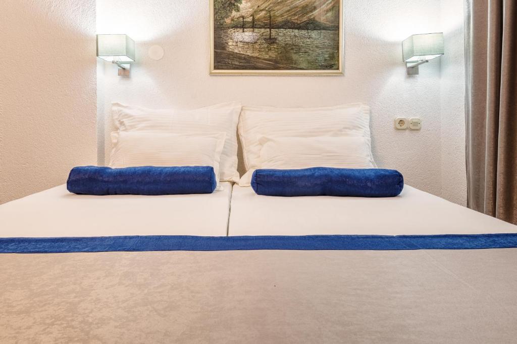 a bed with two blue pillows on top of it at Apartments Tamaris in Neum