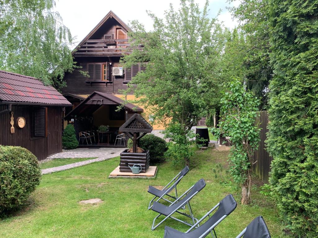 ブランにあるChalet Milenium Residence Branの椅子とグリルがある庭と家