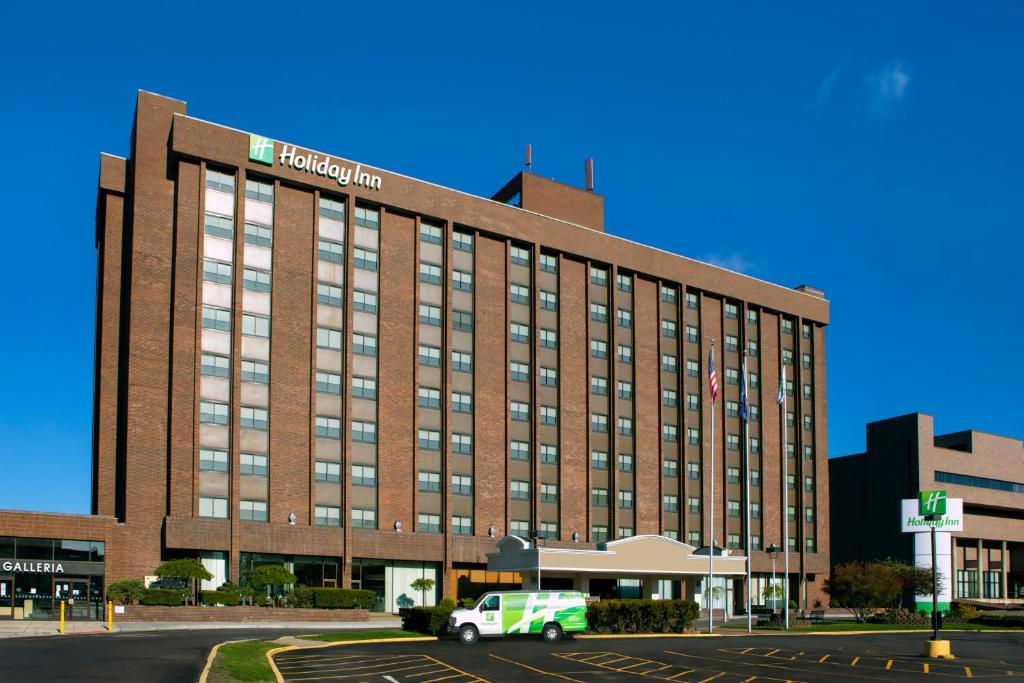 ein großes Backsteingebäude mit einem LKW davor in der Unterkunft Holiday Inn Binghamton-Downtown Hawley Street, an IHG Hotel in Binghamton