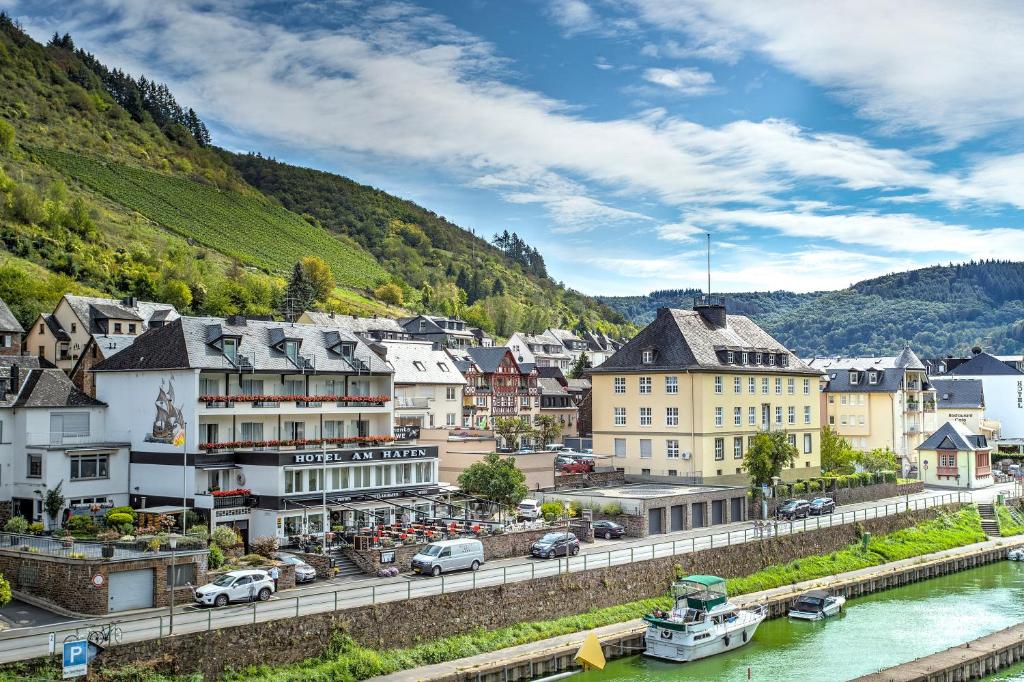 a town next to a river with a mountain at Hotel am Hafen in Cochem