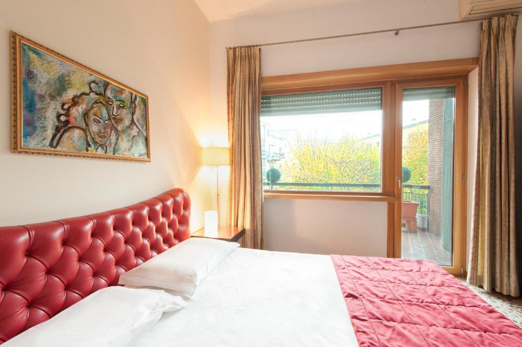 una camera con letto con testiera rossa e finestra di Hotel Piazza Marconi a Cassino