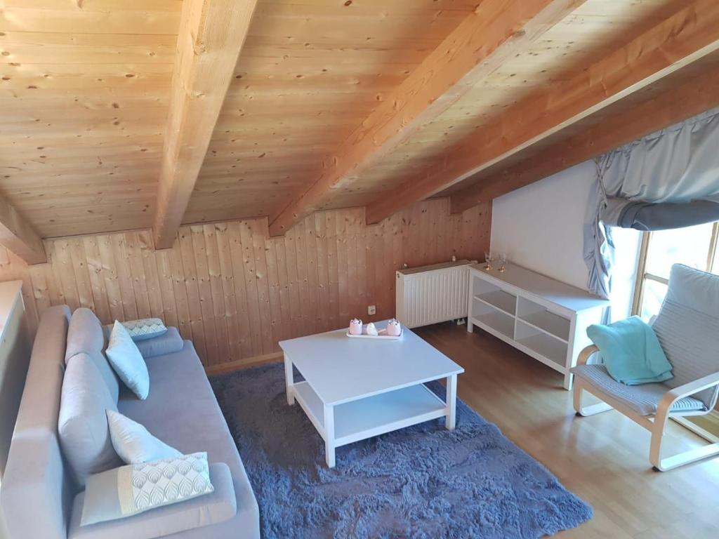 uma sala de estar com um sofá e uma mesa em Ferienwohnung-am-Chiemsee em Grabenstätt