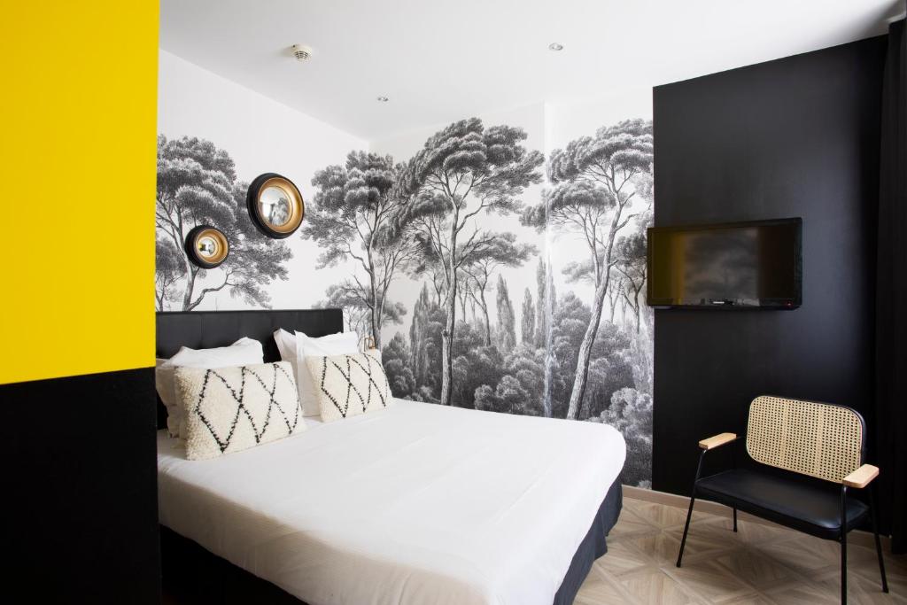 a bedroom with a white bed and a black and white wallpaper at Hôtel Mademoiselle in Juan-les-Pins