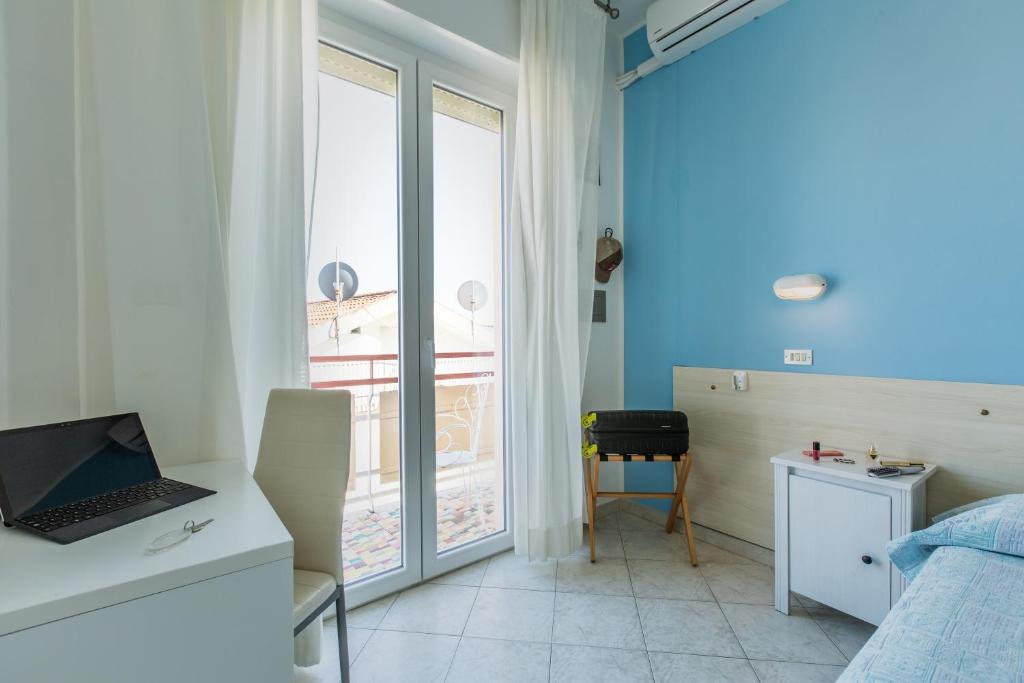 a bedroom with a laptop on a desk and a window at Hotel Sant'Angelo in Riccione