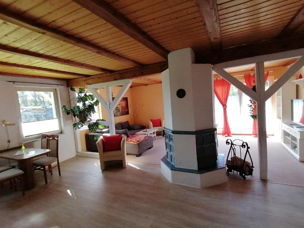 uma sala de estar com um fogão no meio de uma sala em Ferienwohnung am Haffberg em Neverow