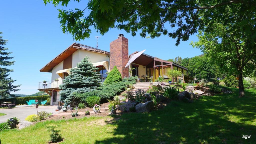 une maison avec un jardin en face dans l'établissement Chambres d'Hôtes de l'Avison, à Bruyères