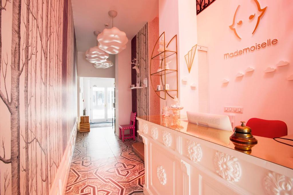 a hallway with pink walls and a desk in a room at Hôtel Mademoiselle in Juan-les-Pins